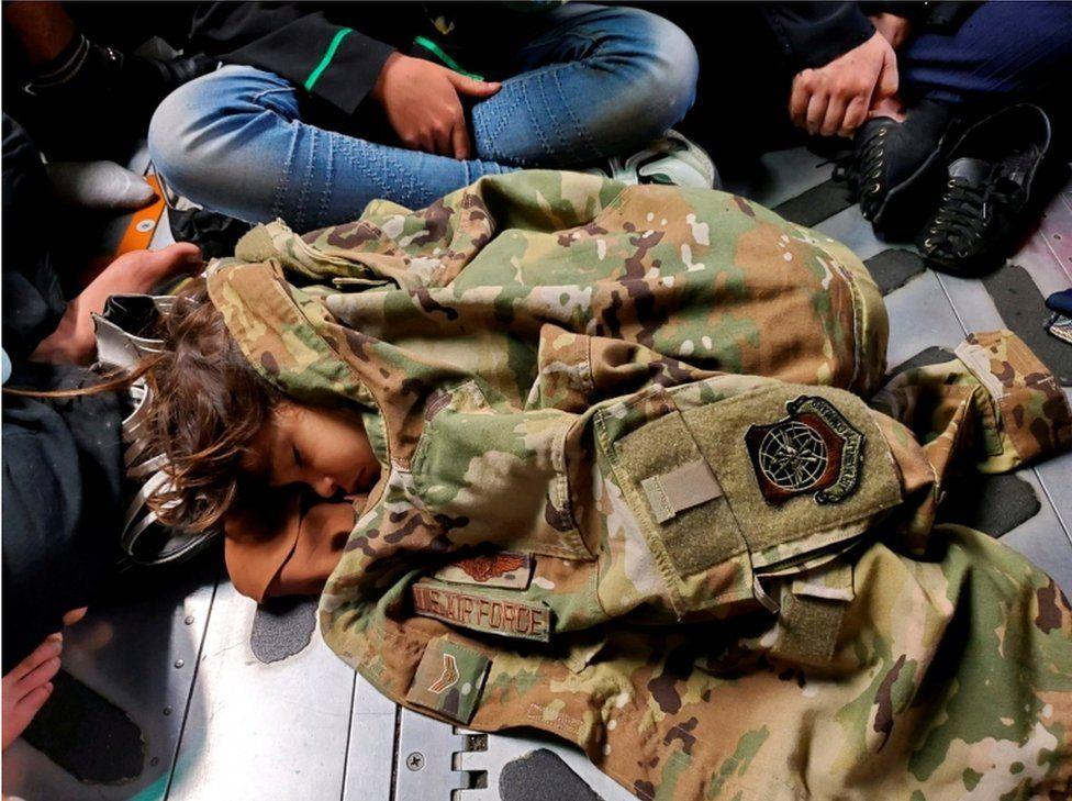 An Afghan child sleeps on the floor of a U.S. Air Force plane during an evacuation flight from Kabul